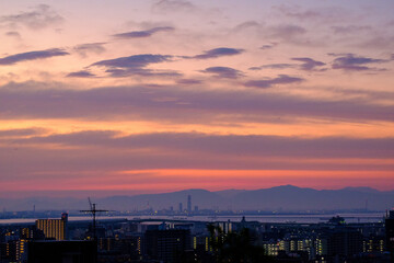 神戸市内の高台の岡本梅林公園より神戸市街地、大阪湾、背景に生駒山系を臨む。夜明け前のマジックアワー。あたりはオレンジ色に染まる