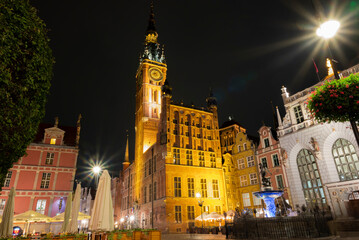 view of the square at night in the old town with the town hall and sculpture of Neptune in Gdansk Poland