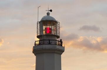 Burning lighthouse against the background of the twilight sky.