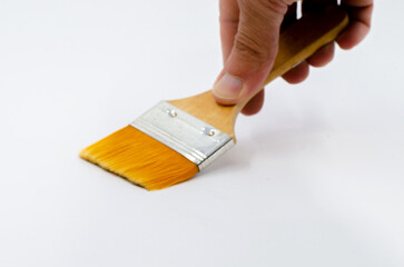 human hand holding a brush. Hand holding silk-tipped brush on white isolated background. Yellow paint brush.
