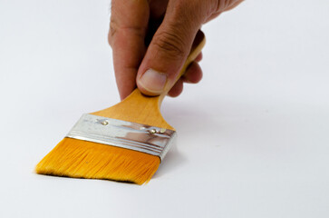 human hand holding a brush. Hand holding silk-tipped brush on white isolated background. Yellow paint brush.
