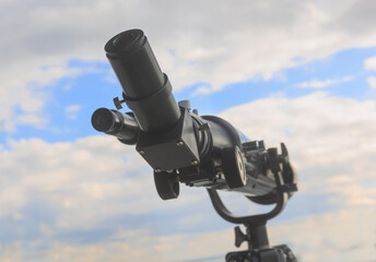 Telescope aimed at the cloudy sky