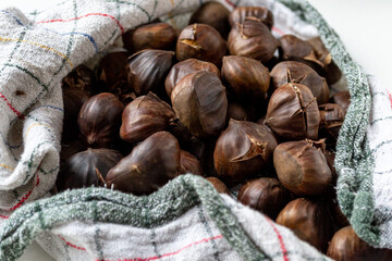A pile of hot roasted chestnuts wrapped in a towel