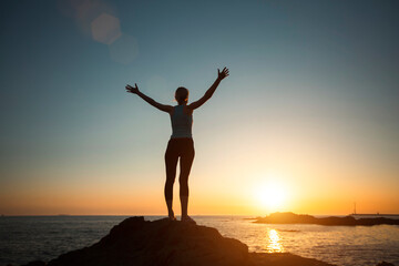 Fototapeta na wymiar Silhouette of a yoga woman seeing off the sun on the ocean.
