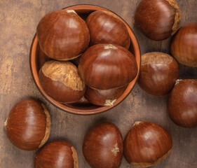 Edible chestnuts on dark rustic background.  Horse chestnuts top view. Flat lay. Autumn food concept