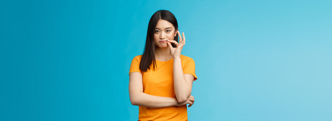 Serious-looking asian female friend promise keep secret, seal lips, hold zip near mouth look...