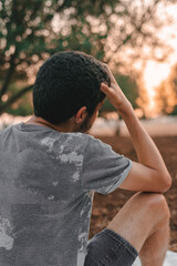 Young Arab model sitting on a white picnic blanket outdoors