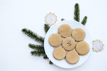 Homemade sandwich cookies with cream coffee filling inside and coffee icing on top, Christmas decoration around plate