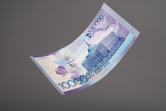 10000 banknote. Kazakhstan money - tenge. Close up of flying tenge on grey background.