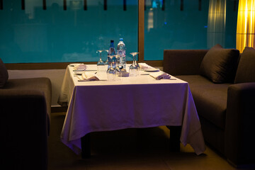 Empty dinner table with wineglasses and dishes on it