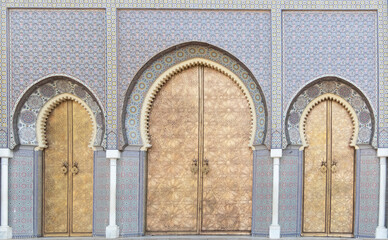 Blue arched tiled doorway iwth three golden doors