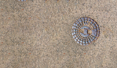 Water valve plate cover for small circular hole cap in the middle of grey asphalt