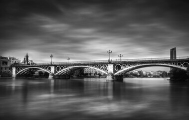 Triana bridgeSeville’s most popular bridge made from iron and moving clouds on sky long exposure...