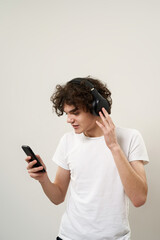 Boy watch phone and listen music in headphones.