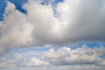 White cumulus clouds in the blue sky. Bright beautiful sky, copy space background