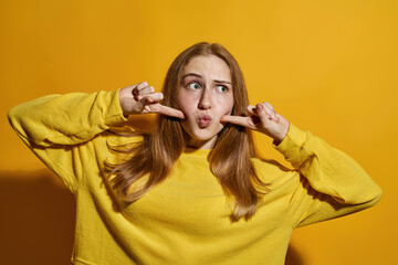 Girl touching cheeks with fingers and looking away