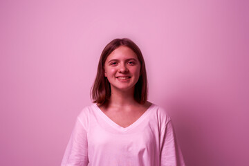 Fototapeta premium Portrait of smiling girl look at camera on pink