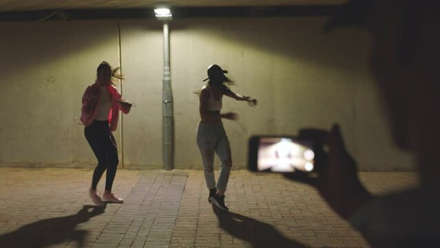 Influencer, smartphone filming and hip hop dancer women with talent, creative energy for fitness or youth lifestyle. Creative gen z teenager girl group dancing together at night for social media