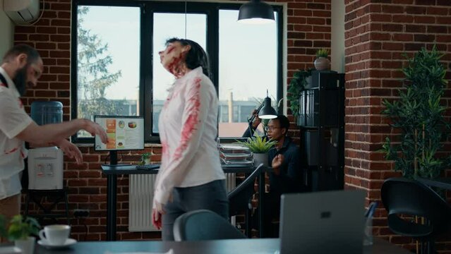 Shocked african american man hiding from mindless creepy zombies in office. Scared victim surviving apocalypse at work while hiding from bizarre animated corpses and trying to call emergency.