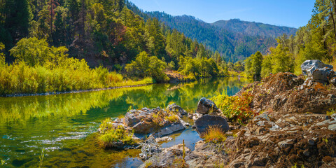 Autumn foliage and tranquil water reflections over the rocky creek on Trinity River near Del Loma,...