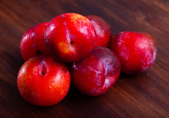 Fototapeta na wymiar Fresh red plums on wooden table, natural sweet snack