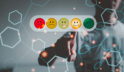 Customer service evaluation concept. man Is using a smartphone And she is pressing face emoticon smiling in satisfaction on virtual touch screen.