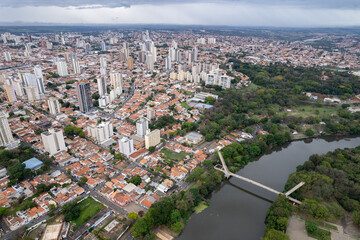 Aerial photography of the city of Piracicaba. Rua do Porto, recreation parks, cars, lots of vegetation and the Piracicaba river crossing the city.