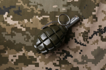 Hand grenade on digital camouflage fabric, top view