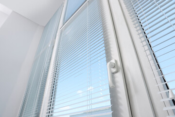 Fototapeta na wymiar Window with horizontal blinds indoors, low angle view