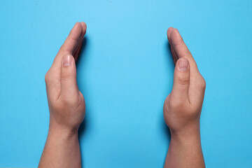 Woman holding on light blue background, closeup of hands. Space for text