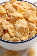 Bowl of tasty corn flakes on table, closeup