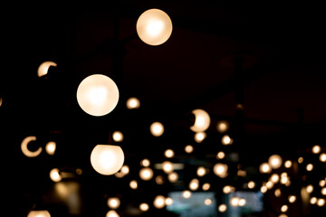 abstract blurred background of lights. Abstract blurry dark indoor plaza hall with a lot of small...
