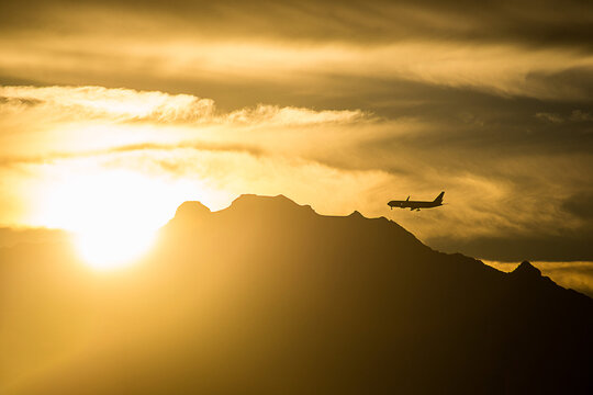 Backlight photography of an airplane flying over the Iztaccihuatl at sunrise, one of the highest mountains in Mexico. 