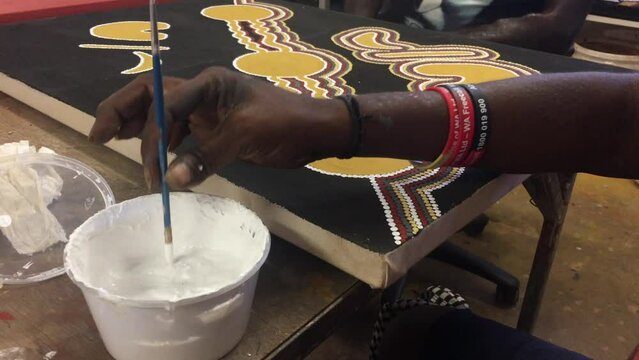 Aboriginal woman artist hand dot painting