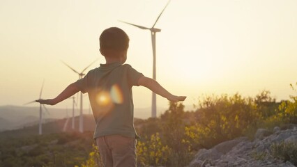 Lifestyle video melted hands and flies at sunset near windmills. The concept of children's happiness and dreams. Wind turbine renewable energy sources. High quality 4k footage