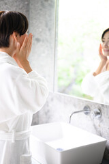 Fototapeta premium 鏡を見て肌を気にする女性