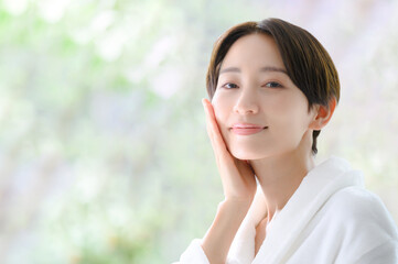 肌を手で触れる美容に使いやすい女性　カメラ目線