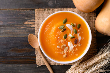 Butternut squash pumpkin soup in bowl on wooden background, Homemade food in autumn season