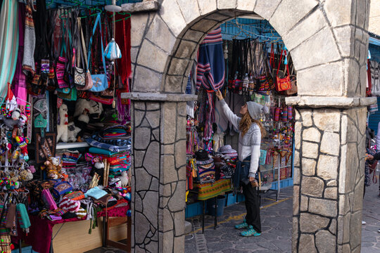 Tourist woman traveling and looking at souvenirs in an outdoor craft market in Peru.  Tourism and vacations in Peru.  Colca Valley, Chivay.