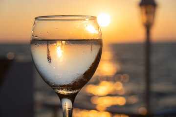 Glass of white wine at sunset near seaside with copy space