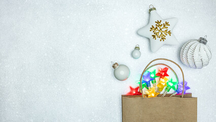 christmas paper bag with star and glass ball in paper bag with glowing holiday lights. top view on...