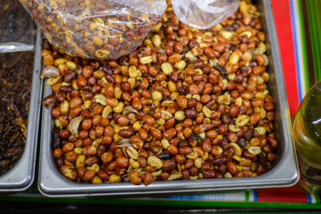 Container with roasted peanuts with salt, garlic and chili. Sold in street markets