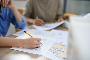 Concept of engineering consulting, Two female engineers discuss and sketches blueprint of building