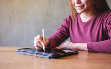 Closeup of a woman using stylus pen technology for working and writing on digital tablet screen