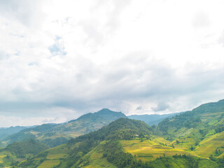 Naklejka premium Aerial view of golden rice terraces at Mu cang chai town near Sapa city, north of Vietnam. Beautiful terraced rice field in harvest season in Yen Bai, Vietnam