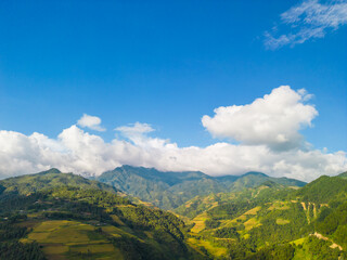 Fototapeta premium Aerial view of golden rice terraces at Mu cang chai town near Sapa city, north of Vietnam. Beautiful terraced rice field in harvest season in Yen Bai, Vietnam
