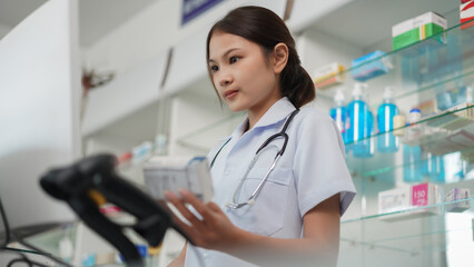 Medicine and health concept, Female pharmacist hold medicine product to working with cash register