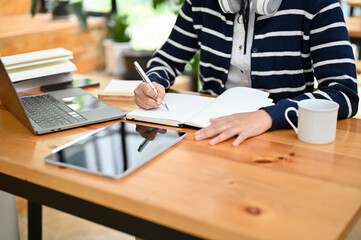 Fototapeta na wymiar Asian female college student doing homework in the library. cropped shot