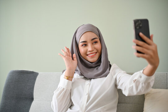 Beautiful Asian Muslim Woman Wearing Hijab Video Calls Her Friends On Her Smartphone