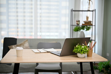 Fototapeta premium Modern urban office working room with office desk, laptop, office supplies, office chair and decor.